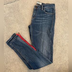 Skinny jeans with red zipper on legs